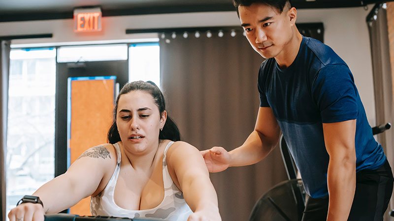 A personal trainer shown motivating a person working out.