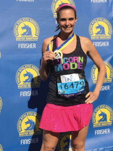 A photograph of Tara Collingwood holding her medal at the Boston Marathon.